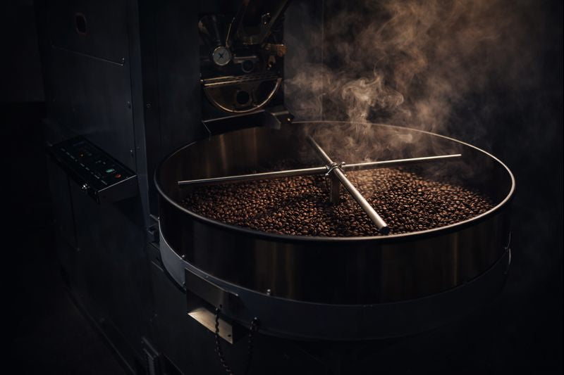 Coffee beans being roasted in a coffee roaster with smoke