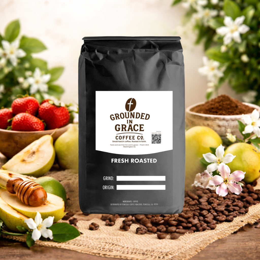 Grounded in Grace coffee bag with fresh roasted coffee beans and fruits on a wooden surface.