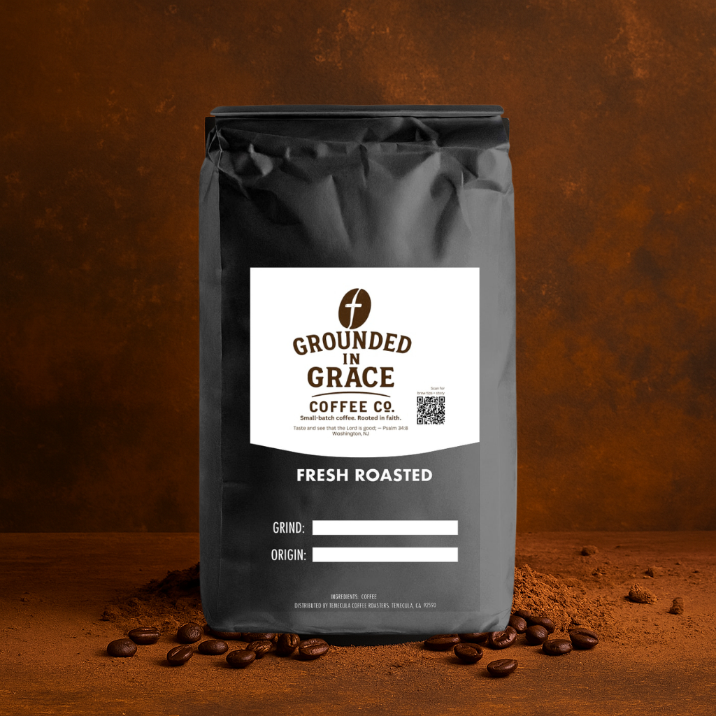 Black coffee bag with 'Grounded in Grace Coffee Co.' label on a brown background with scattered coffee beans.