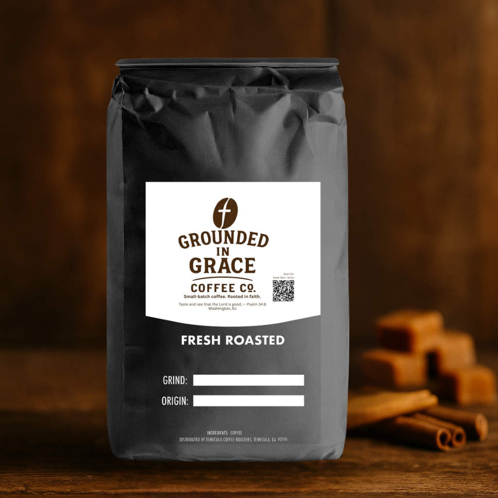 Grounded in Grace Coffee Co. Blessed Caramel flavored coffee bag on a wooden surface with cinnamon sticks.