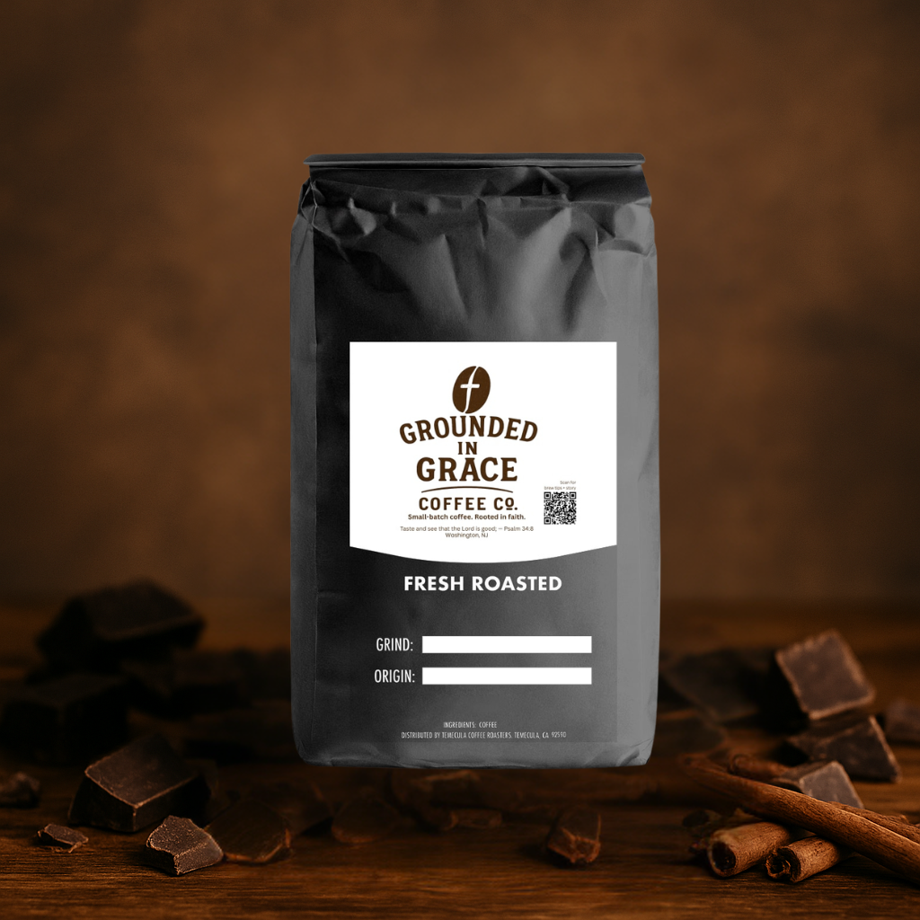 Coffee bag labeled 'Grounded in Grace Coffee Co. Divine Mocha' with chocolate pieces and cinnamon sticks on a wooden surface.